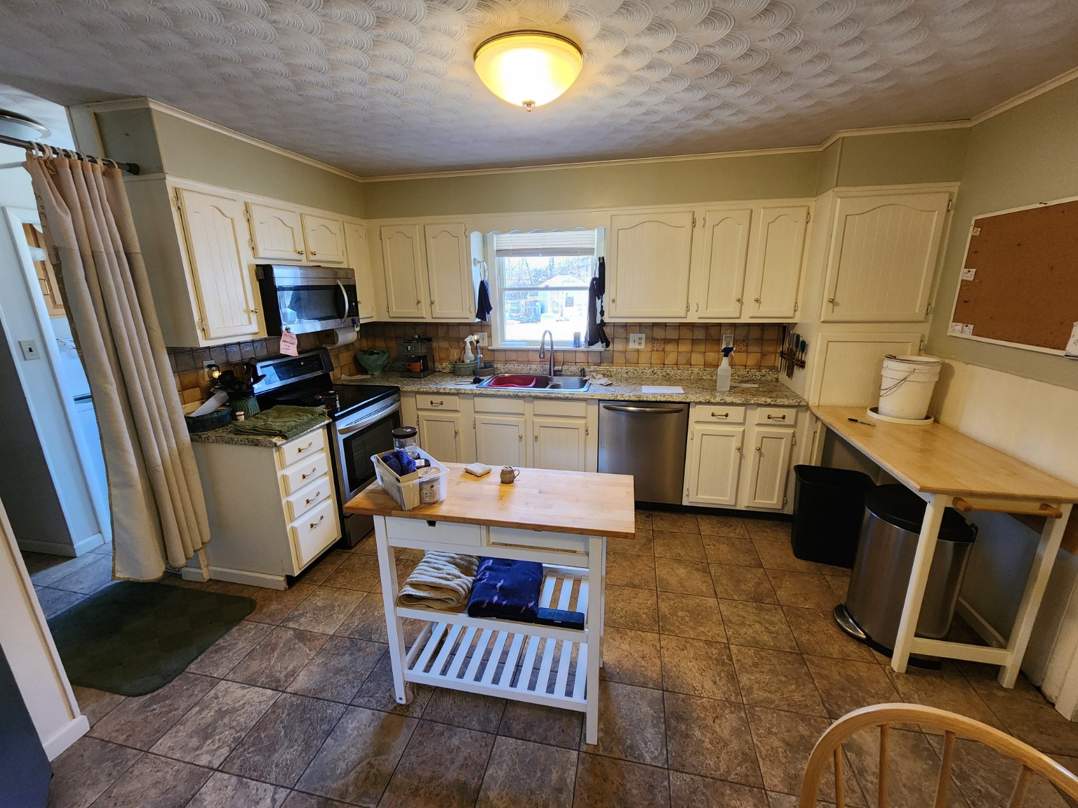 Before — kitchen cabinets, textured ceiling and tile floor