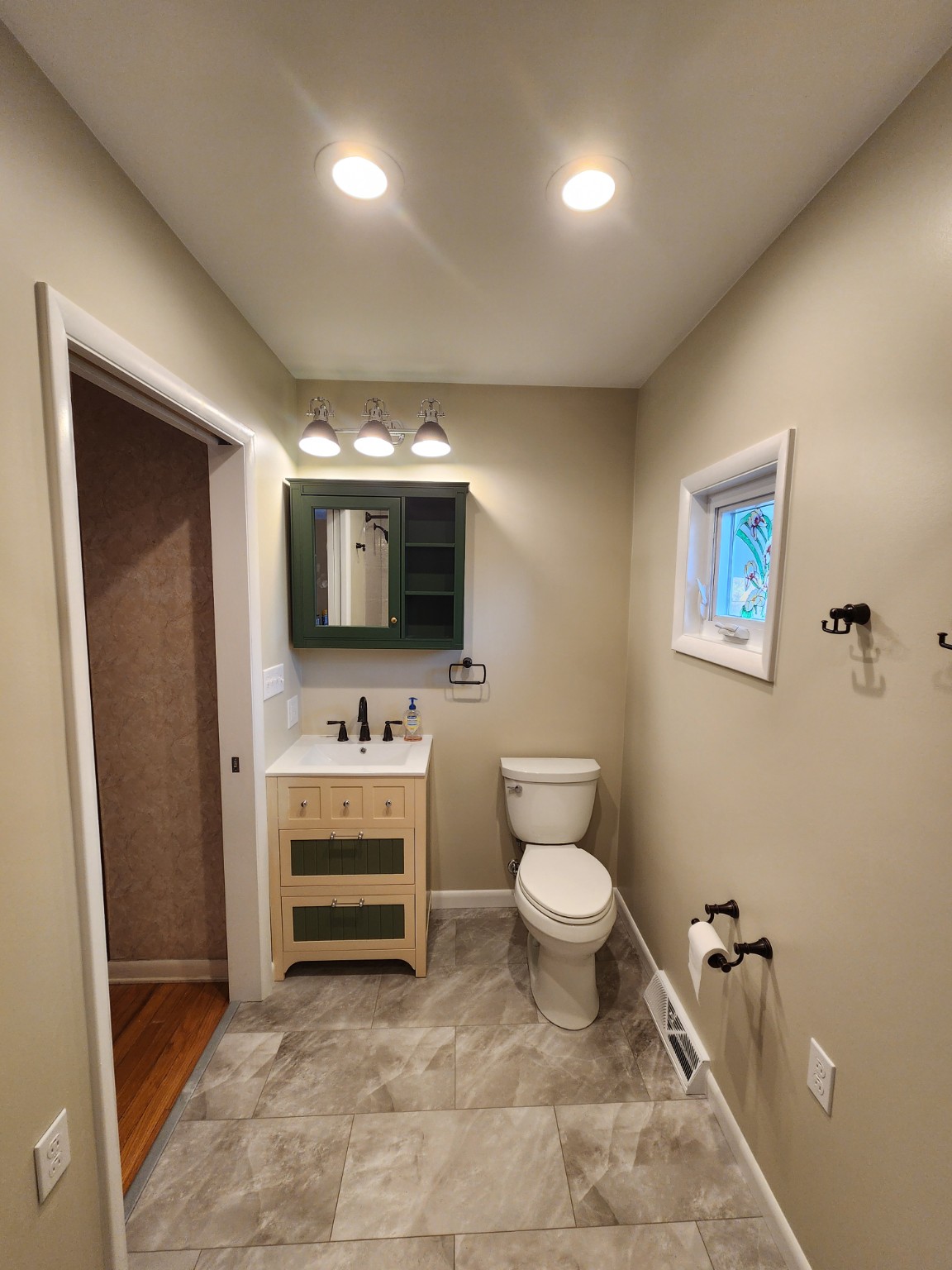 After: finished bathroom with new vanity, lighting and flooring