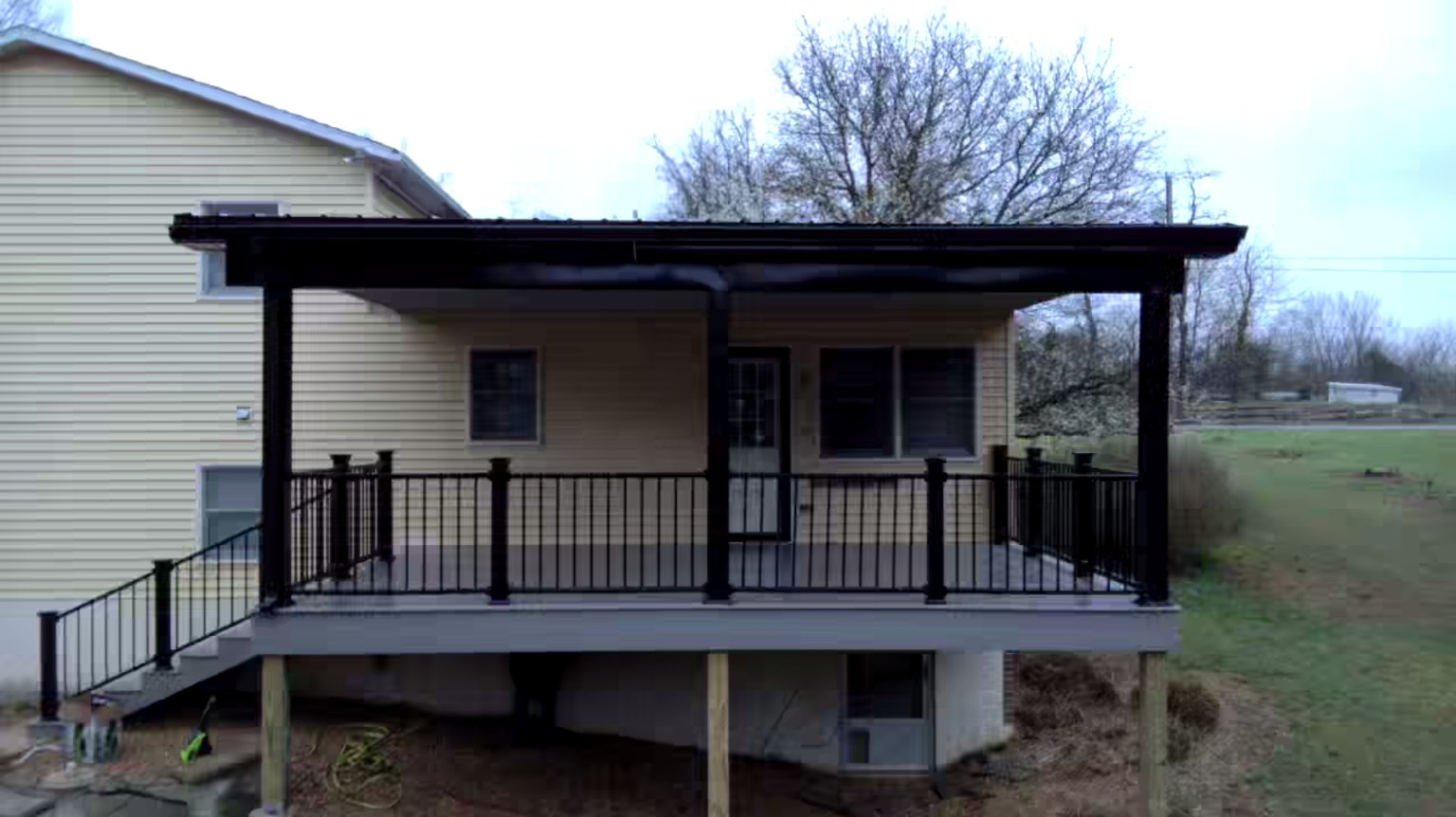 After: new raised covered porch with gray decking and black railings