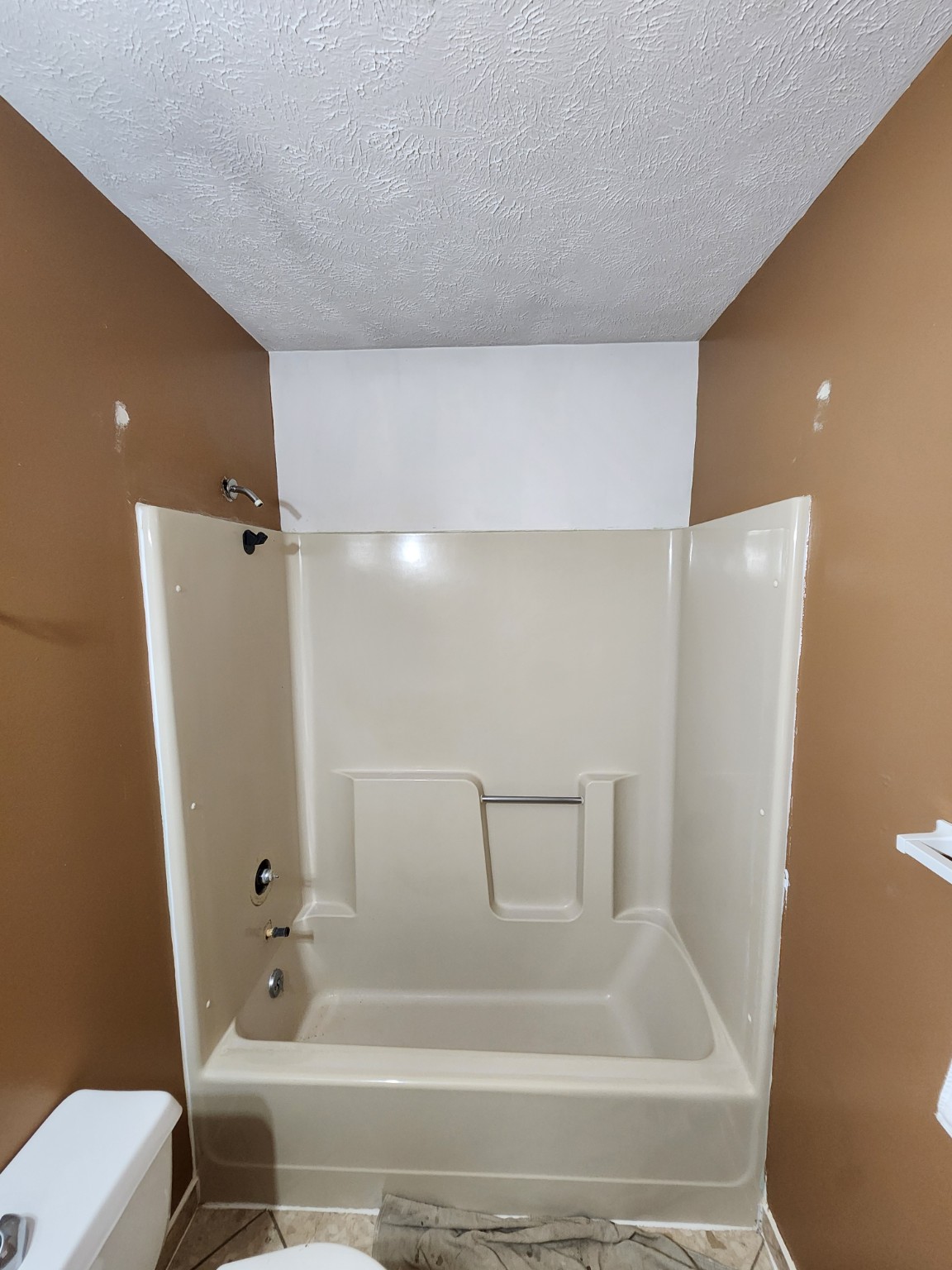 Before: Bathtub surround in a tan bathroom