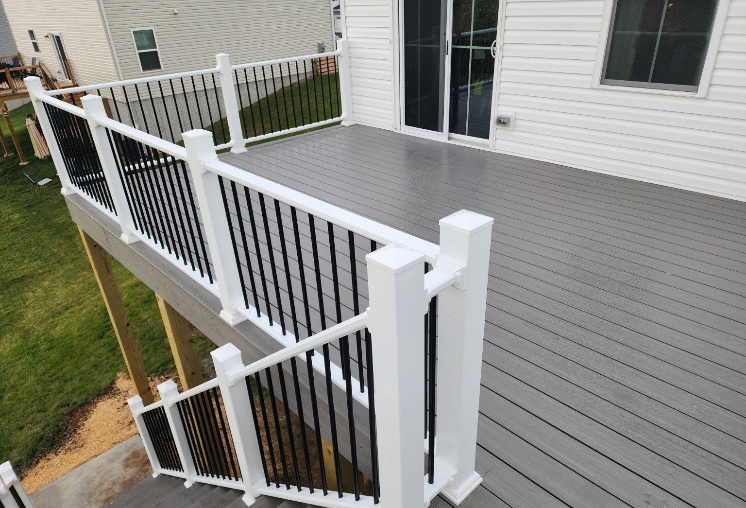 After: new raised gray deck with white railings and black balusters
