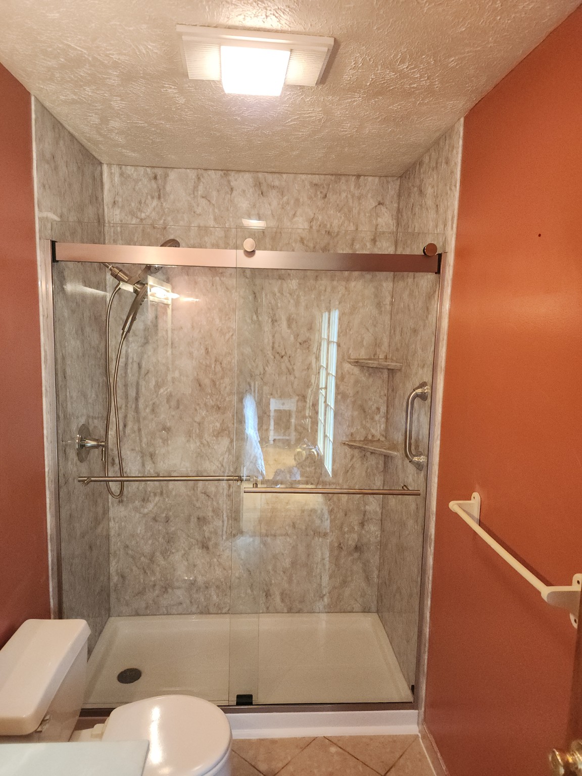 After: Tub-to-shower conversion with marble-look walls