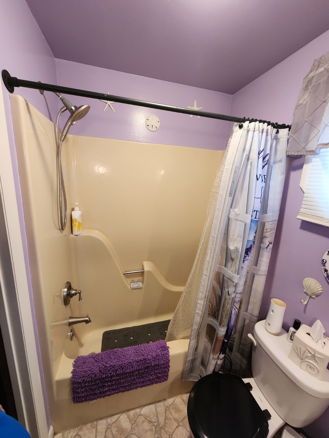 Before: Bathtub and shower curtain in a purple bathroom